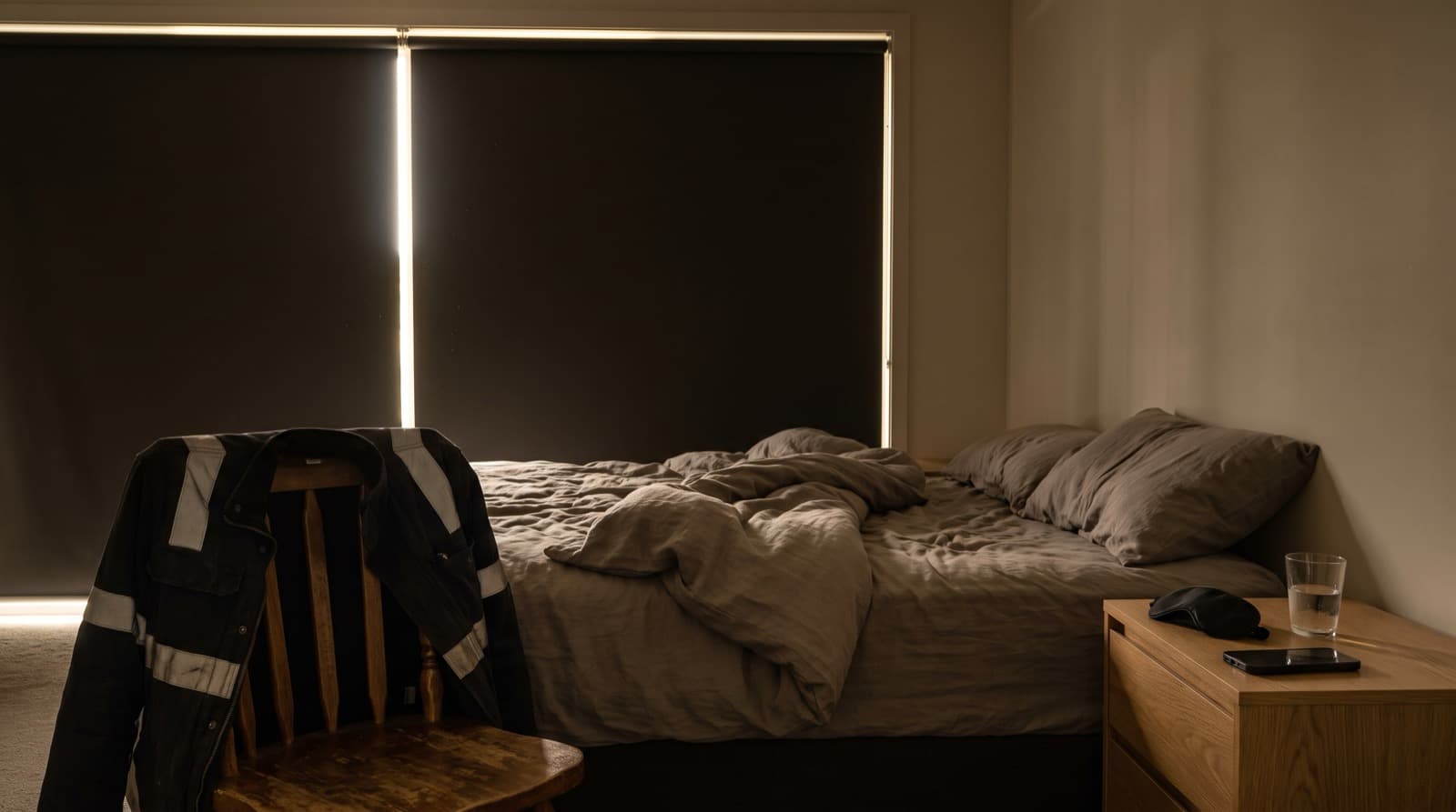 Verdunkeltes Schlafzimmer am Tag, Arbeitsjacke über dem Stuhl